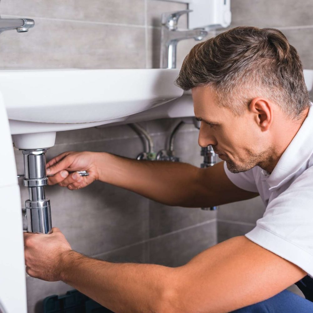 adult-plumber-fixing-sink-at-bathroom.jpg adult-plumber-fixing-sink-at-bathroom.jpg